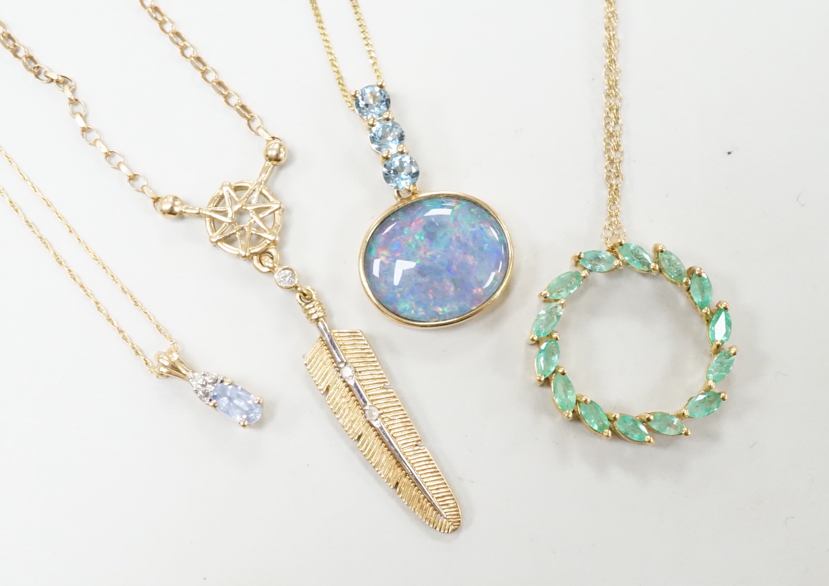 Three assorted modern 9ct or yellow metal and gem set pendants, on 9ct chains including opal doublet and blue topaz, feather shape and emerald set circular and a similar 10k pendant, on a 10k chain, longest 52cm, gross w